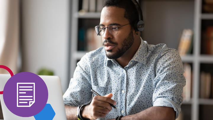 Man wearing headphones and looking at laptop