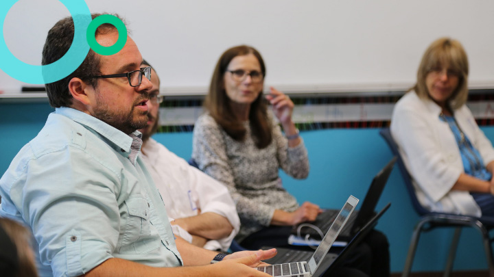 Teachers sitting in group and working on laptops