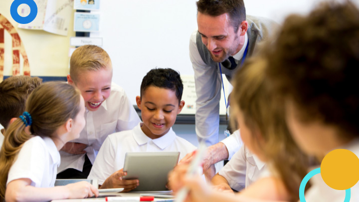 Teacher helping group of students use tablet