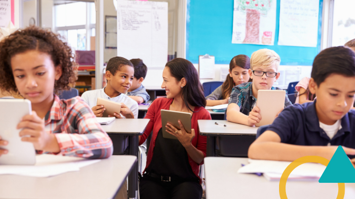 Teacher talks with student in classroom.