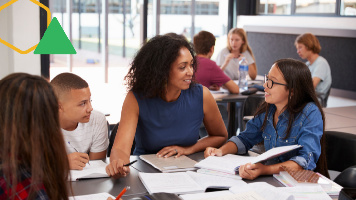 Teacher sits with group of students.