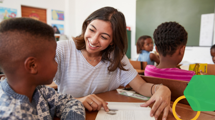 Smiling teacher working with young student.